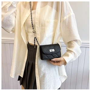 Détail d'un petit sac matelassé noir avec bandoulière chaîne et bille de réglage argent