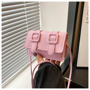 Detailansicht einer kleinen rosa Mikrofasertuch-Umhängetasche mit dekorativen Schnallen