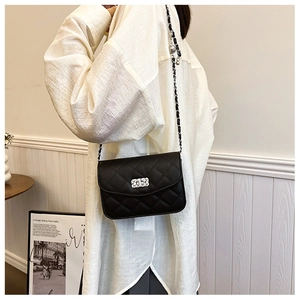 Détails du sac bandoulière noir matelassé avec fermoir argenté et bandoulière en chaîne