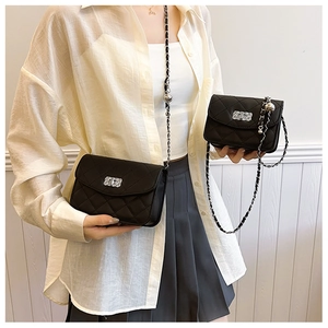 Detail of black quilted crossbody bags with silver chain straps in two sizes
