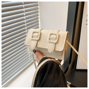 Detail einer mini cremefarbenen Ledertasche mit schicken Doppel-Riemenschnallen