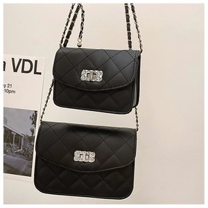 Close-up of black quilted small square bag with chain strap and silver twist lock
