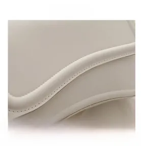 Macro shot of white leather bag featuring precise stitching and smooth rounded edges