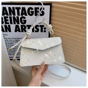 Detail of white star sequin handbag with unique knotted rope handle and detachable strap