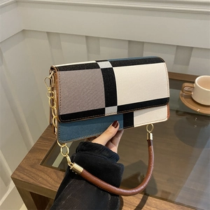 Chic patchwork shoulder bag with geometric blocks in blue, white, and black tones