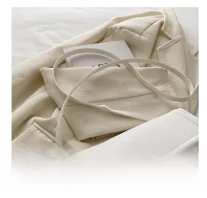 Detail of off-white leather shoulder strap with golden adjustable metal buckle