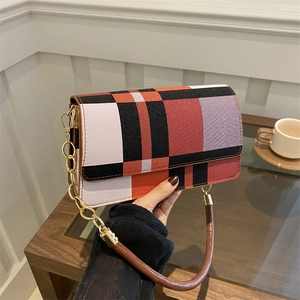 British style plaid crossbody bag with gold chain strap held in a cozy indoor setting