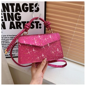 Detail of fuchsia sequined handbag featuring a knotted handle and sleek gold hardware