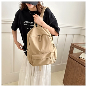 Detail of khaki casual backpack showing multi-pocket design and drawstring side pockets