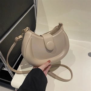 Elegant beige semi-circular crossbody bag with leather texture and large round buckle