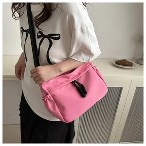 Detail van roze nylon schoudertas met zwart trekkoord en verstelbare brede riem