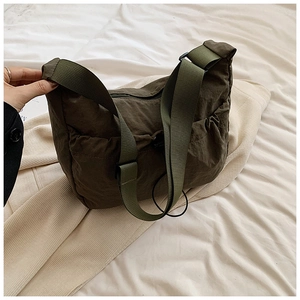 Detailed view of dark olive green shoulder bag featuring soft nylon fabric and wide strap