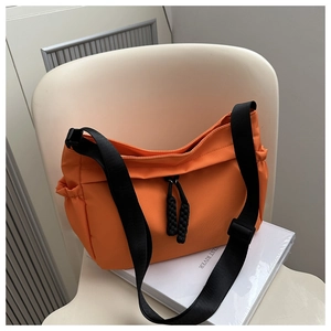 Détail du sac bandoulière en nylon orange vif avec sangle réglable et cordon de serrage