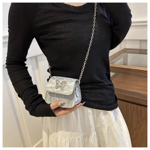 Dettaglio della mini borsa a tracolla argento con farfalla e texture plissettata