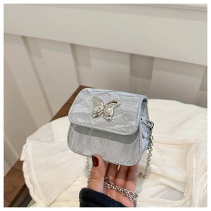 Dettaglio della mini borsa argento con chiusura a farfalla metallica e catenina fine