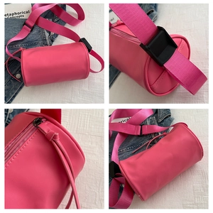 Dettagli della borsa a cilindro rosa con cerniera, fibbia e texture liscia in pelle