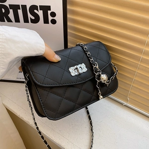 Sac bandoulière noir matelassé avec chaîne et pendentif en forme de boule argentée