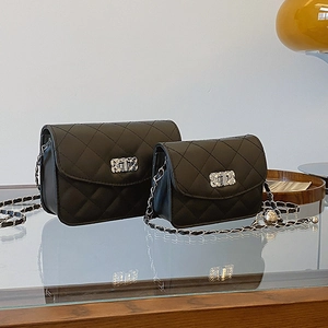 Petit sac carré noir matelassé avec bandoulière chaîne et fermoir argenté élégant