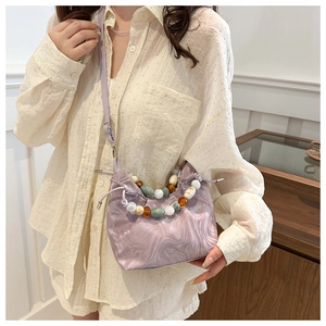Detail of light purple marble texture bag with decorative chunky gemstone beaded handle