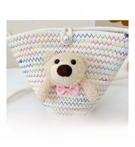 Detail of white woven mini bag with colorful wavy stitching and plush bear with pearl clasp