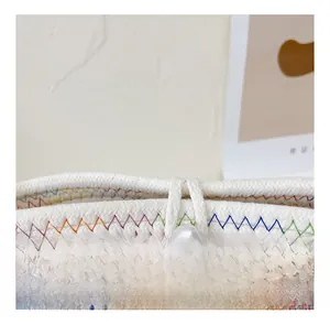 Close-up of rainbow zigzag stitching and large pearl button on white woven bag