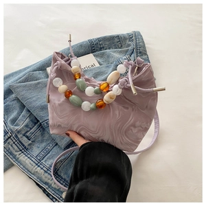 Detail of light purple marble pattern bucket bag with colorful beaded top handles