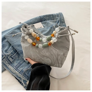 Detail of grey marble bucket bag with colorful acrylic beaded handle and chic drawstring base