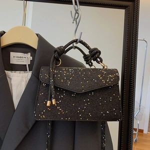 Elegant black handbag with sparkling star sequins and unique knot handle design