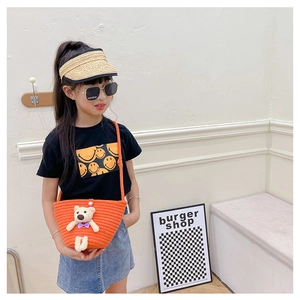 Orange mini woven crossbody bag with cute plush bear on a child summer outfit display