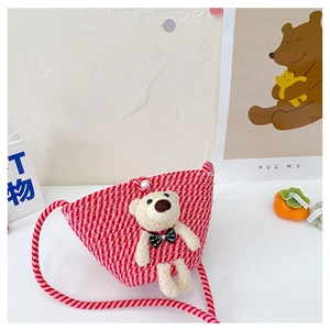 Detail of hand-woven mini bear crossbody bag with pearl clasp and pink knit texture