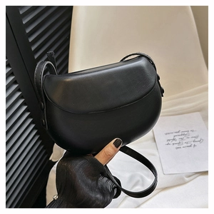 Close-up of minimalist black saddle bag with smooth leather finish and adjustable strap