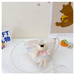 Detail of cute woven mini bag with plush bear, pearl button and cotton rope strap
