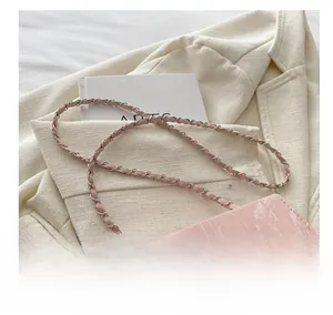 Close-up of pink marble pattern bag with silver metal bow and leather chain strap