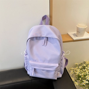 Minimalist lavender high-capacity nylon backpack with side drawstring pockets on a bench
