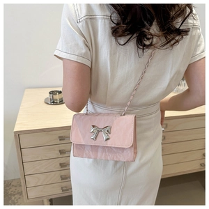Close-up of pink crossbody bag with pleated texture and silver metal bow detail