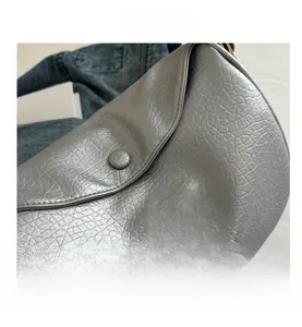 Close-up of silver-gray textured leather bag featuring a pink butterfly embroidery detail