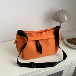 Sac fourre-tout orange en nylon avec cordon de serrage noir et bandoulière réglable