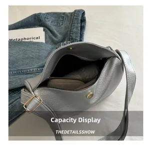 Detail showing interior capacity of large silver hobo bag with zip and buckle closure