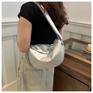 Dettaglio della borsa hobo argento metallizzato con ricamo a farfalla rosa e tracolla larga