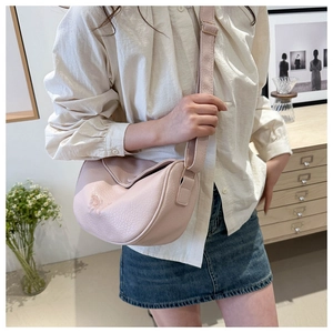 Dettaglio borsa dumpling rosa con ricamo a farfalla e trama in pelle a grana litchi