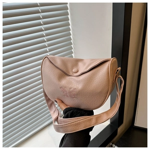 Detail of pink crinkle textured crossbody bag featuring delicate butterfly embroidery