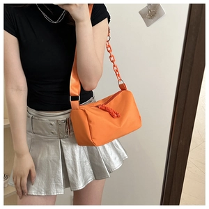 Detail of orange nylon shoulder bag with plastic chain strap and wide woven belt