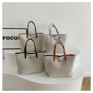 Minimalist canvas tote bags with leather handles in four colors on a white display