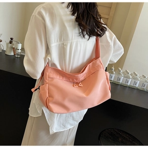 Detail view of pink nylon tote bag with dual zipper compartments and ergonomic strap