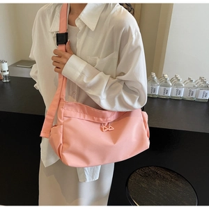 Pink nylon tote bag detail showing adjustable wide shoulder strap and functional side pocket