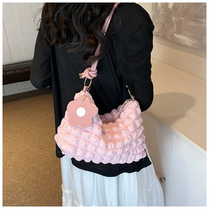 Detailed shot of pink bubble textured shoulder bag with a floral charm accessory