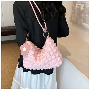 Detailed texture of pink bubble fabric shoulder bag with a matching floral charm