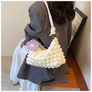 Detail of white bubble texture shoulder bag with purple flower charm and knotted strap