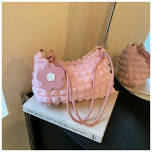 Detail of pink bubble texture shoulder bag with leather flower charm and golden zipper