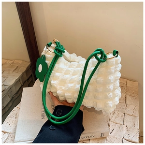 Detail of white bubble texture fabric with green rope handle and sunflower charm